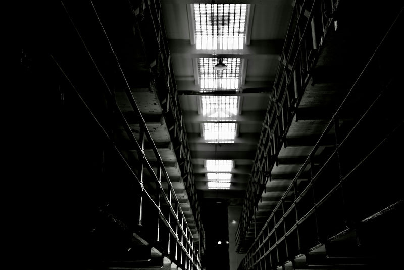 Dark, narrow hallway with bright barred skylights