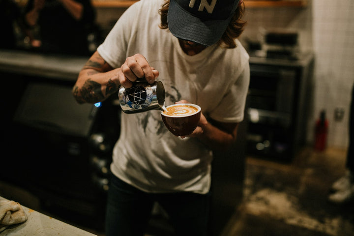 A barista making a café latte