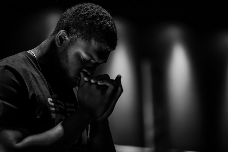 A man with hands clasped in prayer