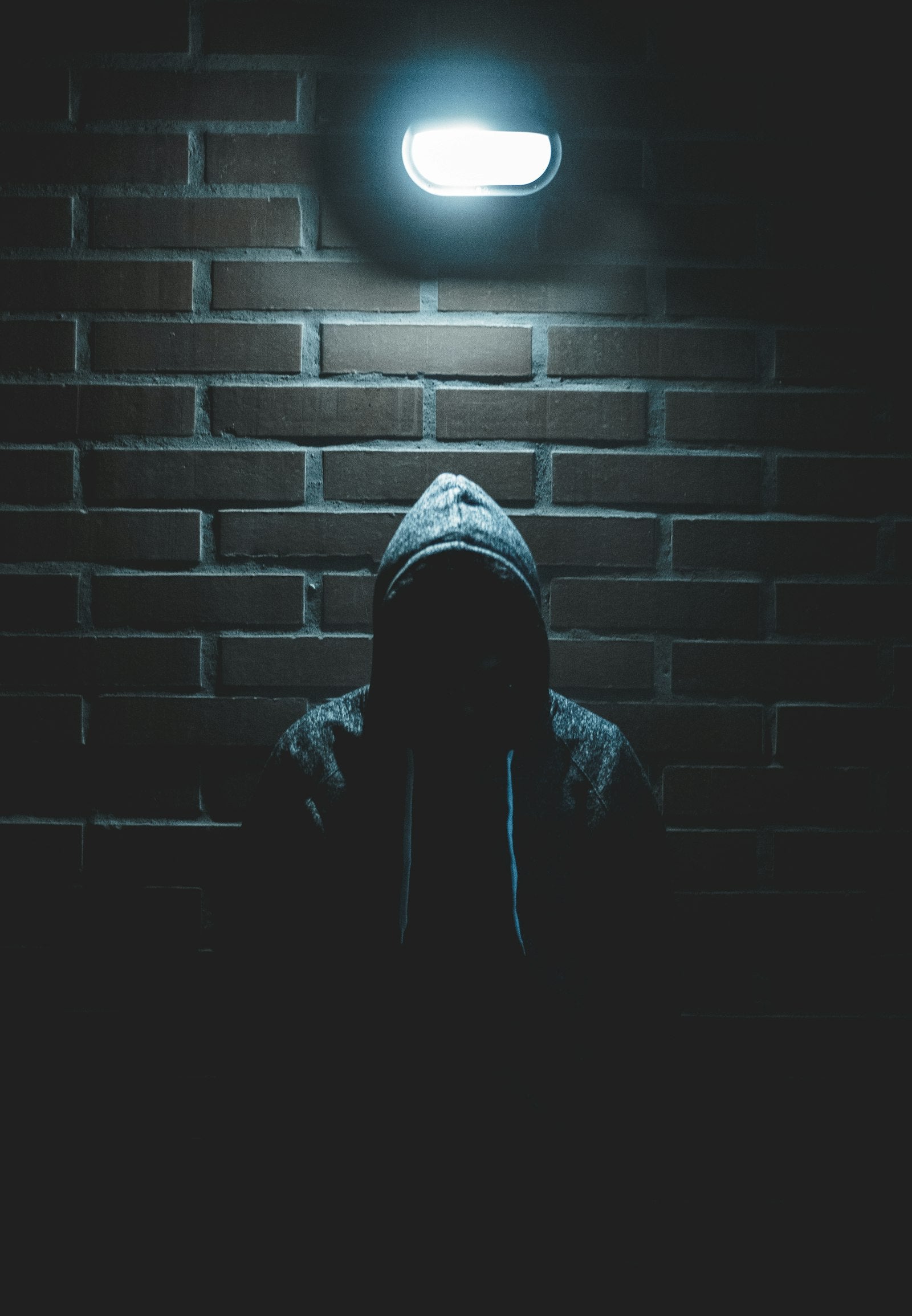 A hooded figure in a shadowed alley