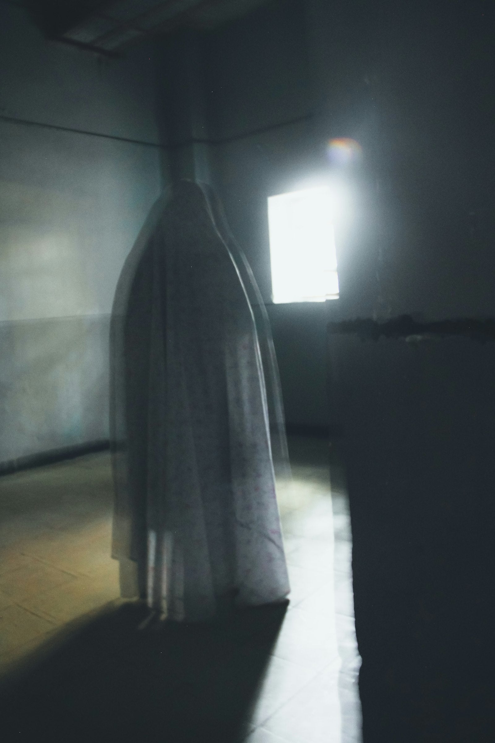 A blurred figure standing in a dark room
