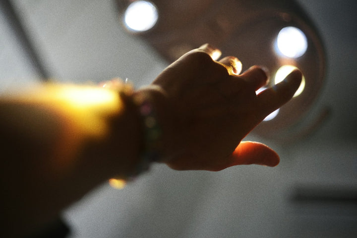 A hand reaching towards bright lights