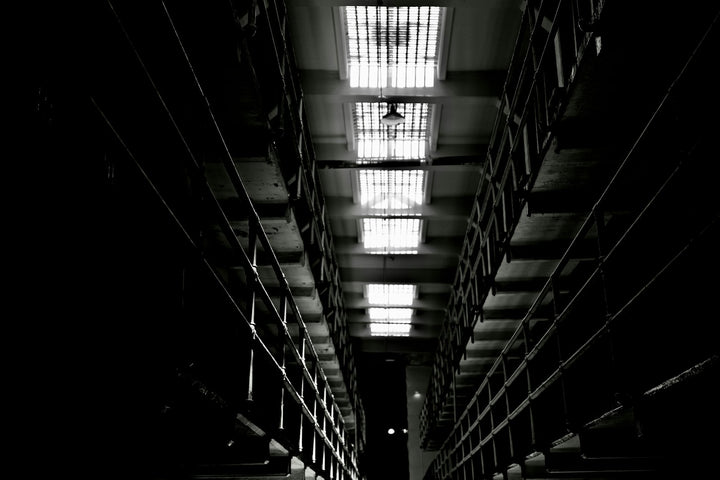 Dark, narrow hallway with bright barred skylights